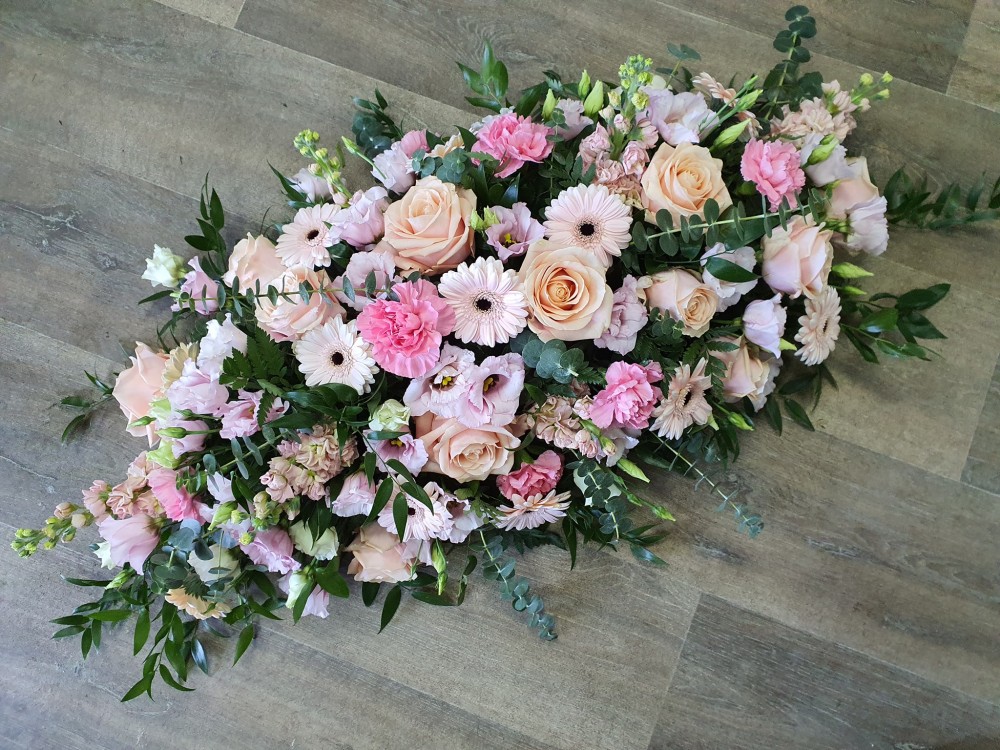 Pastel pinks and peaches casket spray