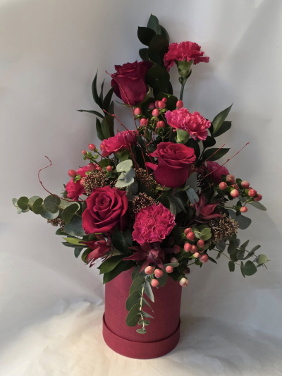 Raspberry delight - lovely arrangment in red/hot pink shades with mix of roses and carnations with foliage and rustic berries