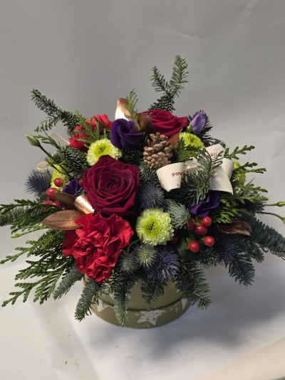 Wintery, lush textered hatbox - This lush hatbox arrangement blends the rich warmth of winter colours with elegant, seasonal textures, striking mix of red, purple and green blooms and natural cones and thistle