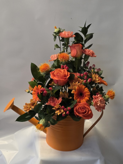 rich autumnal watering can - Experience the vibrant essence of autumn with 'Autumnal Watering Can' from Six Ways Florist in Llanelli. This charming arrangement bursts with warm oranges and rich greens, elegantly displayed in a whimsical watering can. Perfect as a unique gift,